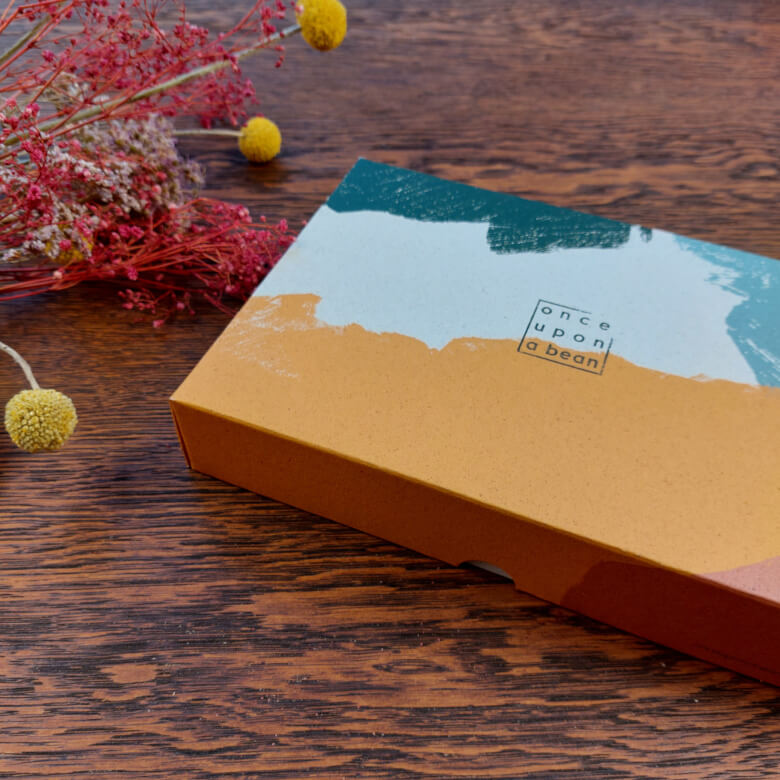 Farbenfrohe Geschenkbox von once upon a bean auf Holztisch